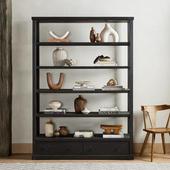 Black wooden bookshelf featuring decorative items like vases, books, sculptures, and bowls neatly arranged on its shelves.