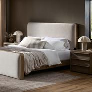 Modern upholstered platform bed with beige fabric, cozy bedding, and wooden side tables in a stylish bedroom.