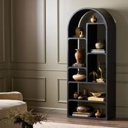 Arched bookshelf with decorative vases and books, standing in an elegant living room corner.