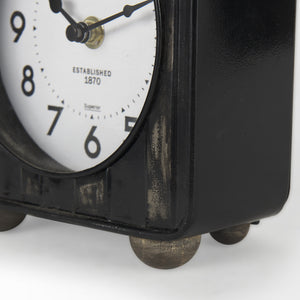 Karl 6.0L x 3.0W x 6.8H Rustic Black Iron Rounded Square Table Clock