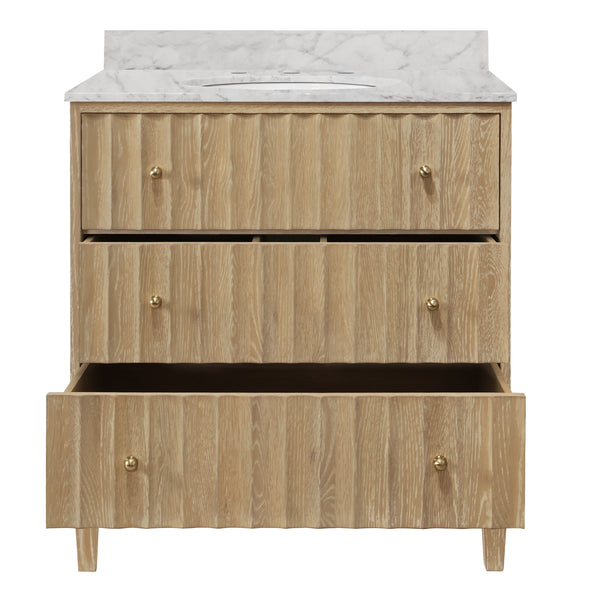 BATH VANITY WITH VERTICAL FLUTED DETAIL ON DRAWERS IN CERUSED OAK WITH WHITE MARBLE TOP, PORCELAIN SINK, AND POLISHED BRASS KNOBS