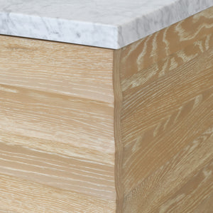 BATH VANITY WITH HORIZONTAL FLUTED DETAIL IN CERUSED OAK WITH WHITE MARBLE TOP, PORCELAIN SINK, AND POLISHED BRASS KNOBS