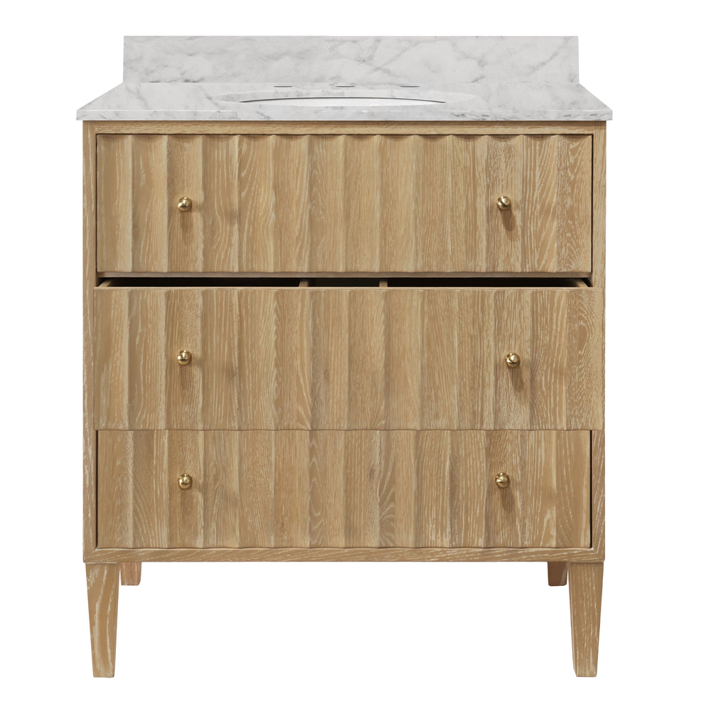 BATH VANITY WITH VERTICAL FLUTED DETAIL ON DRAWERS IN CERUSED OAK WITH WHITE MARBLE TOP, PORCELAIN SINK, AND POLISHED BRASS KNOBS