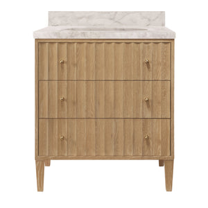 BATH VANITY WITH VERTICAL FLUTED DETAIL ON DRAWERS IN CERUSED OAK WITH WHITE MARBLE TOP, PORCELAIN SINK, AND POLISHED BRASS KNOBS