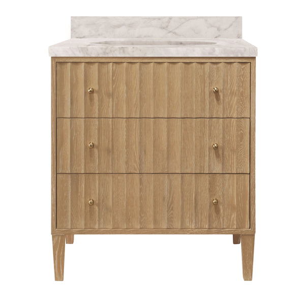 BATH VANITY WITH VERTICAL FLUTED DETAIL ON DRAWERS IN CERUSED OAK WITH WHITE MARBLE TOP, PORCELAIN SINK, AND POLISHED BRASS KNOBS