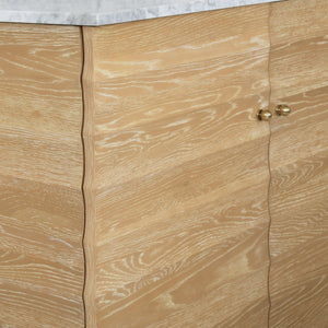 BATH VANITY WITH HORIZONTAL FLUTED DETAIL IN CERUSED OAK WITH WHITE MARBLE TOP, PORCELAIN SINK, AND POLISHED BRASS KNOBS