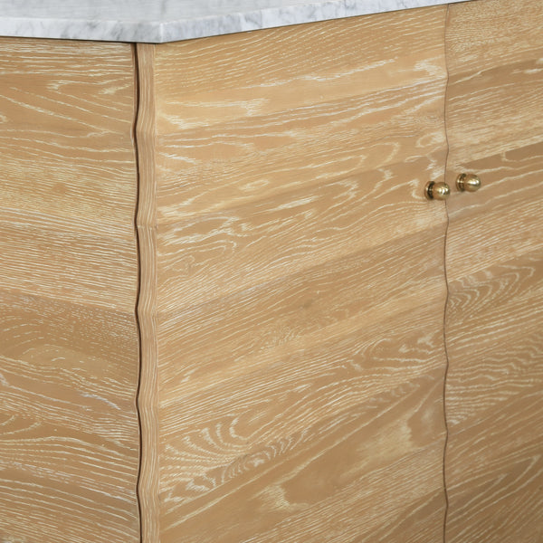BATH VANITY WITH HORIZONTAL FLUTED DETAIL IN CERUSED OAK WITH WHITE MARBLE TOP, PORCELAIN SINK, AND POLISHED BRASS KNOBS